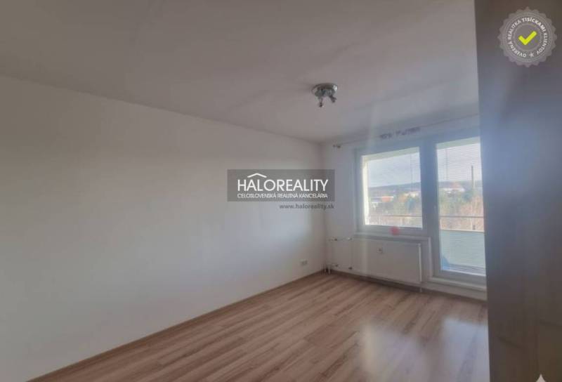 Ein Zimmer mit einem Boden in Holzoptik und einem großen Fenster in einer 3-Zimmer-Wohnung.