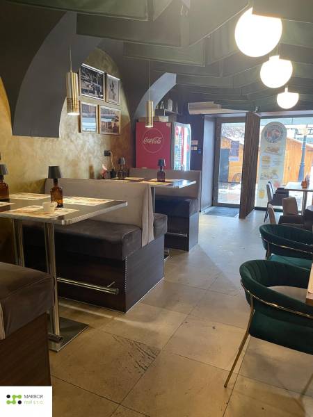 Innenraum eines Gastronomiebereichs mit bequemen Sitzgelegenheiten und dekorativen Leuchten.