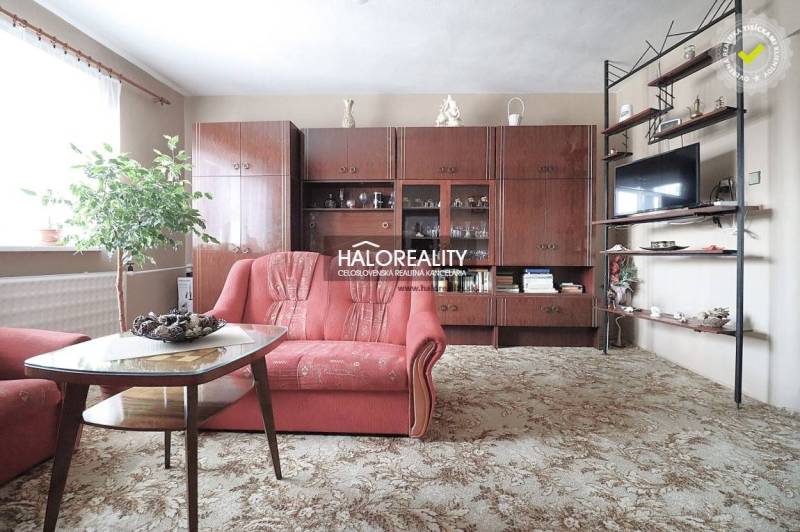 Wohnzimmer in einem Einfamilienhaus mit rotem Sofa und Holzwohnwand.