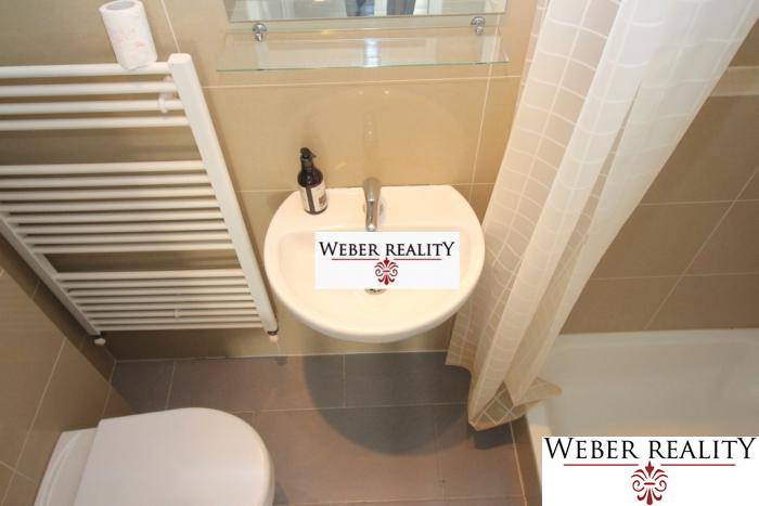 Badezimmer in einer 2-Zimmer-Wohnung mit Duschkabine und Keramikwaschbecken.