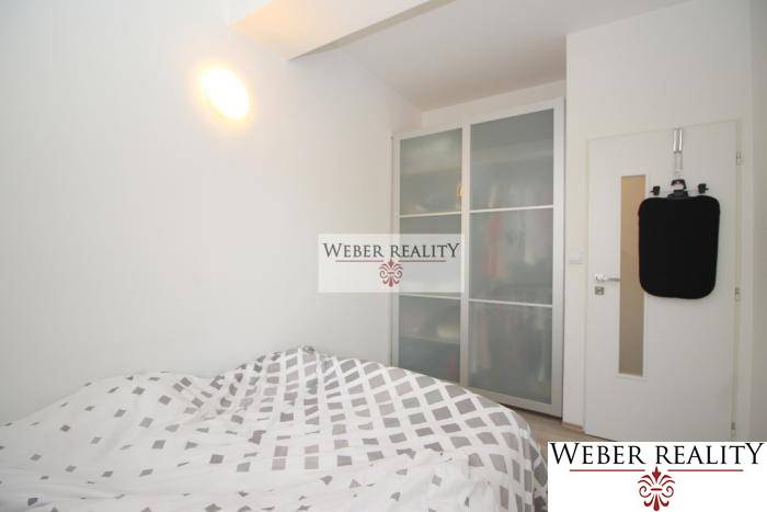 Schlafzimmer mit Doppelbett, Einbauschrank, weiße Wände in einer 2-Zimmer-Wohnung.