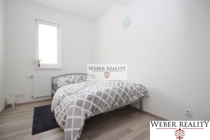 Schlafzimmer in einer 2-Zimmer-Wohnung mit Bett und Boden in Holzoptik.