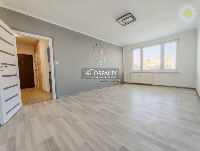 Wohnzimmer in einer 2-Zimmer-Wohnung mit Holzboden und großen Fenstern.