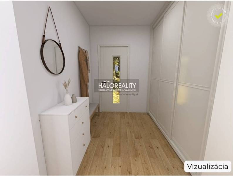 Innenraum eines Einfamilienhauses mit Holzboden, weißer Kommode und Spiegel.