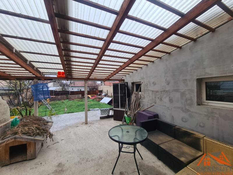 Die Terrasse des Einfamilienhauses in Komárno mit Gartenmöbeln und Überdachung.