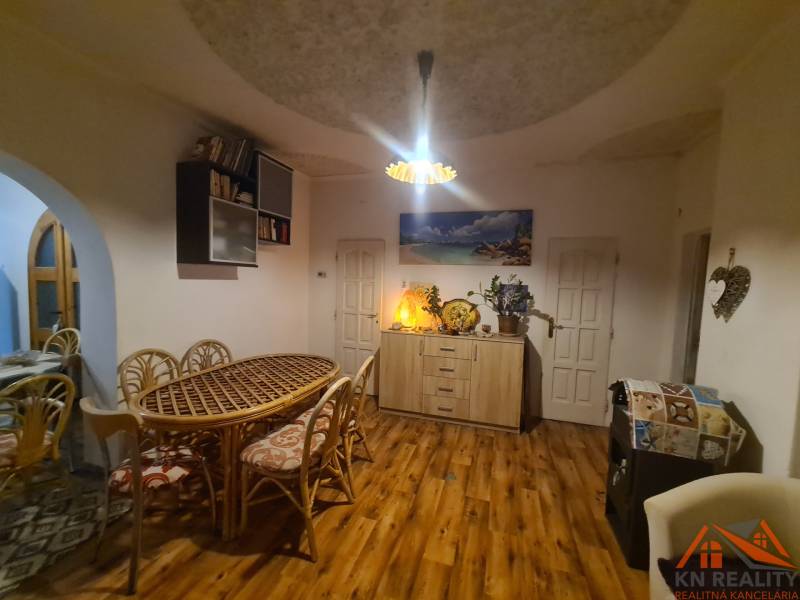 Innenraum eines Einfamilienhauses mit Holzboden, großem Tisch und Dekorationen.