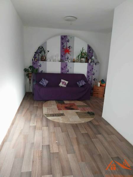 Wohnzimmer in einem Einfamilienhaus mit violettem Sofa und Holzboden.