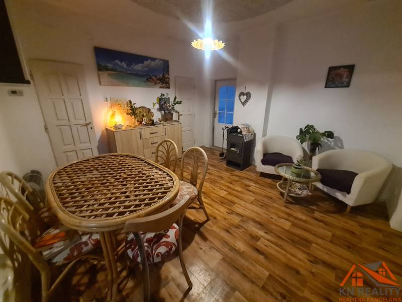 Innenraum eines Einfamilienhauses mit Holzboden, einem Korbtisch und bequemen Sesseln.