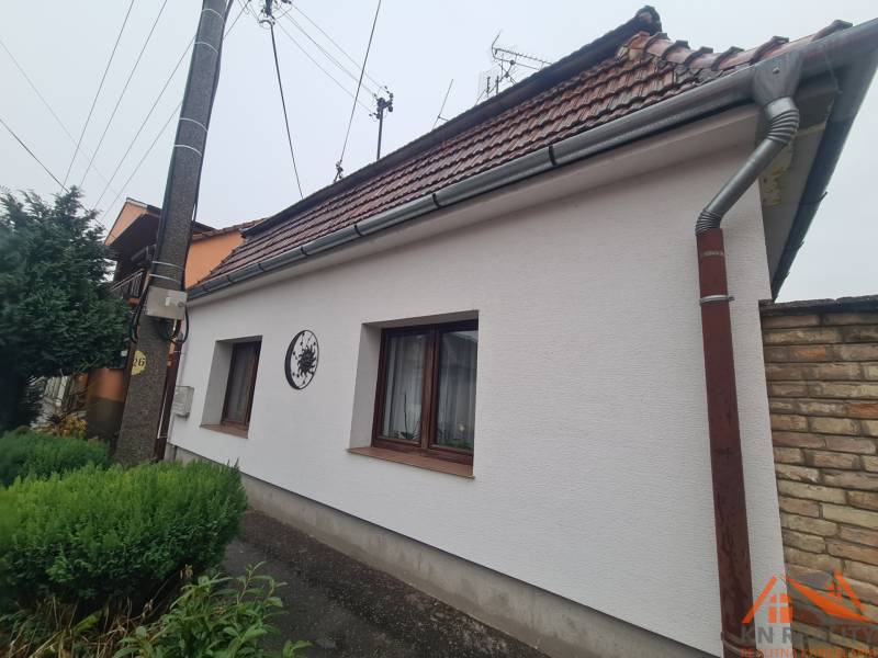 Ein Einfamilienhaus in Komárno mit einem Schrägdach und einem gepflegten Garten.