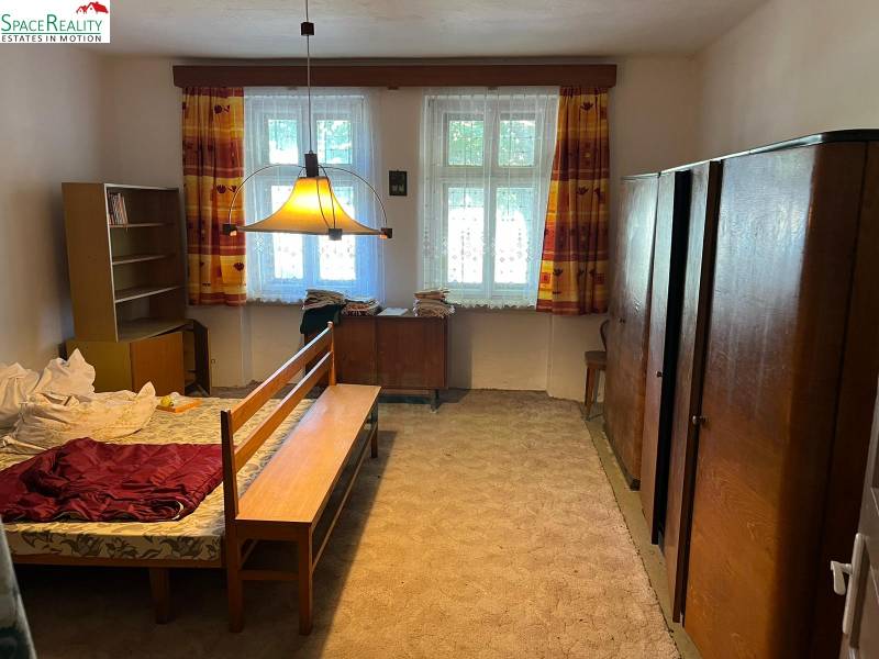 Ein Schlafzimmer in einem Einfamilienhaus mit Teppichboden und Möbeln in hellen Farben.