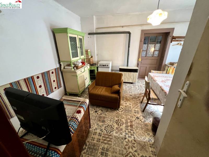 Wohnzimmer in einem Einfamilienhaus mit rustikalen Möbeln und gemustertem Boden.