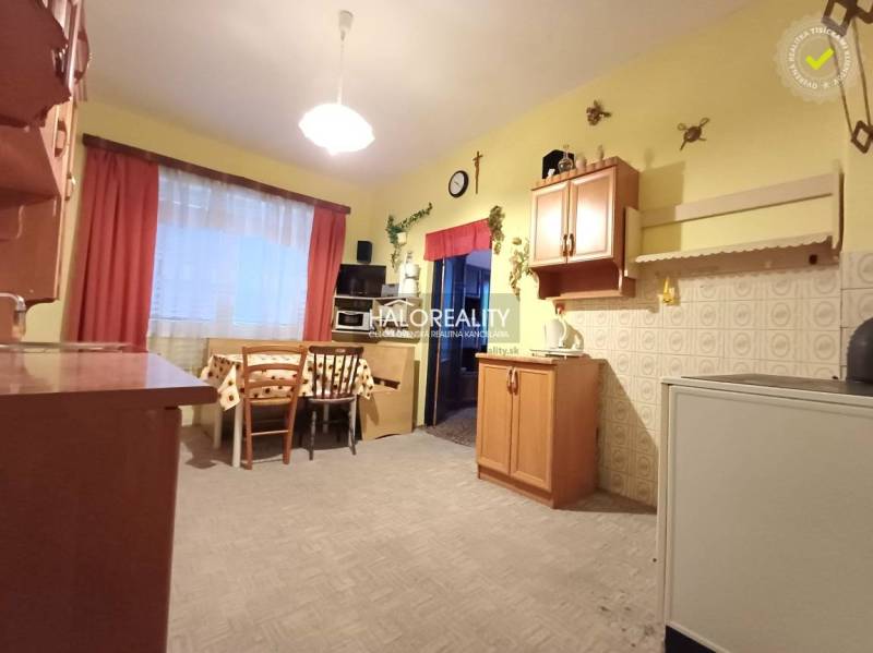 Küche in einem Einfamilienhaus mit Holzdekor, helle Wände, Tisch mit Stühlen.