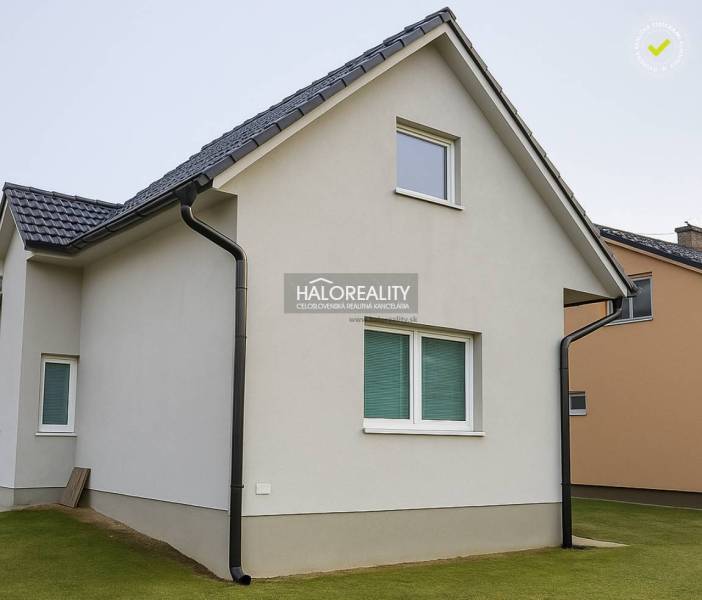 Ein Einfamilienhaus in Kľačno mit weißer Fassade und schrägem Dach auf einem gepflegten Rasen.
