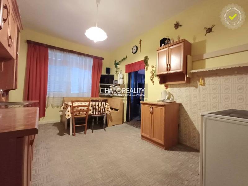 Eine Küche in einem Einfamilienhaus mit Holzelementen, einem Esstisch und Schränken.