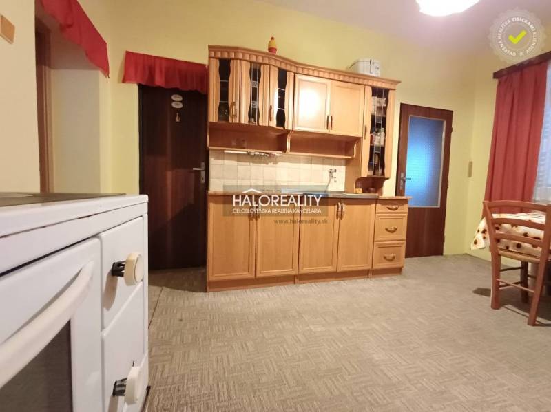 Eine Küche in einem Einfamilienhaus mit Holzschränken und einem klassischen Herd.