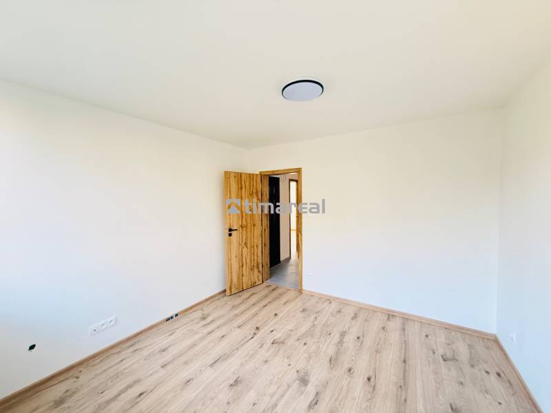 Zimmer in einer 3-Zimmer-Wohnung mit weißen Wänden und einem Boden in Holzoptik.