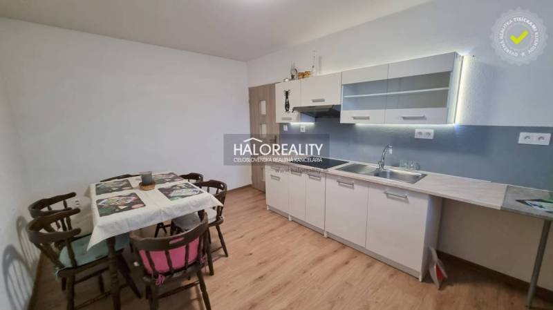 Ein Einfamilienhaus in Poprad mit Rasen, Holzzaun und Nadelbäumen im Hintergrund.