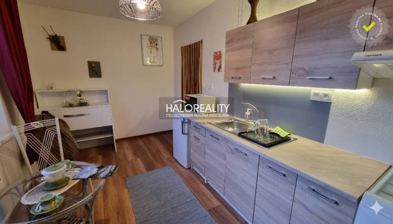 Dachzimmer in einem Einfamilienhaus mit Holzbalken und einem Boden in Holzoptik.