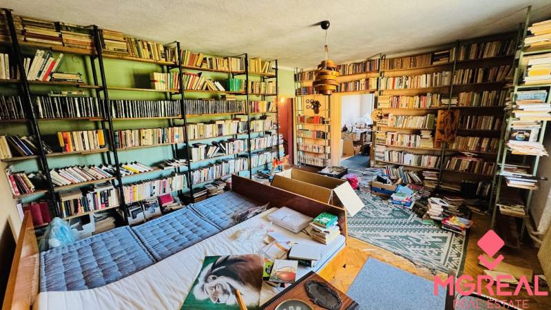 Eine Bibliothek in einem Einfamilienhaus mit vielen Büchern und einem Boden in Holzoptik.