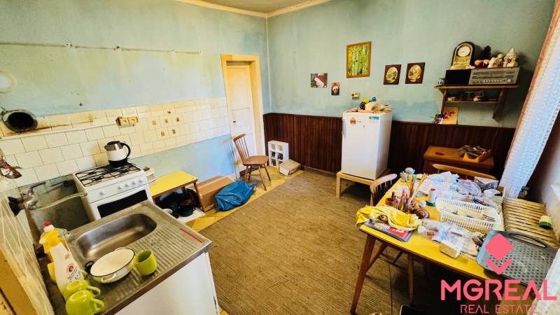 Küche in einem Einfamilienhaus mit Esstisch, älterem Herd und Kühlschrank.