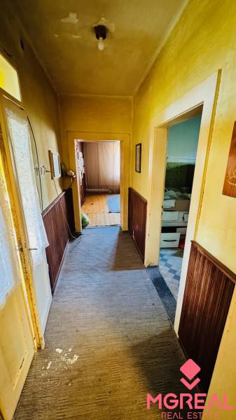 Flur mit Teppich und Holzvertäfelung in einem Einfamilienhaus, Raum rechts.