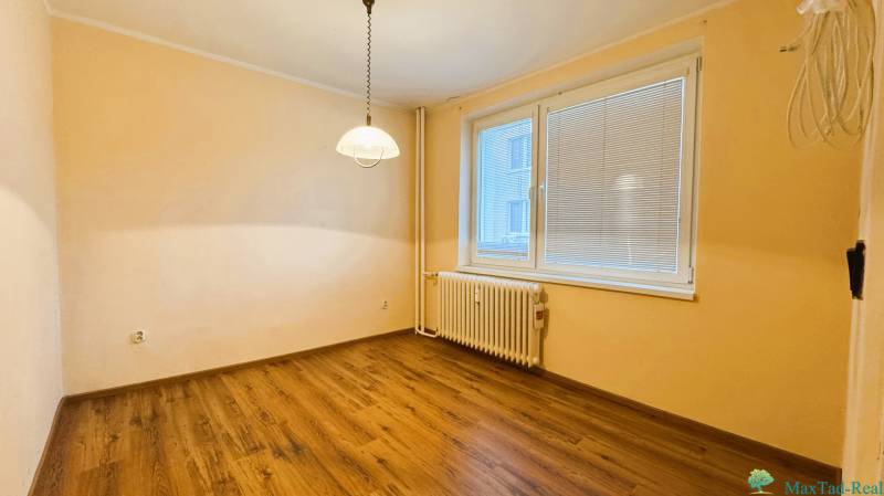 Ein Zimmer in einer 3-Zimmer-Wohnung mit einem Boden in Holzoptik und einem großen Fenster.