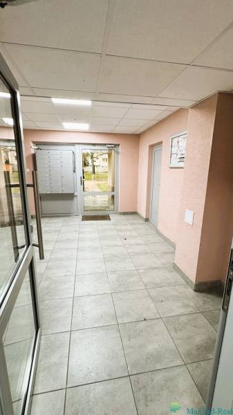 Eingangshalle eines Wohnhauses mit Briefkästen und Glastüren.