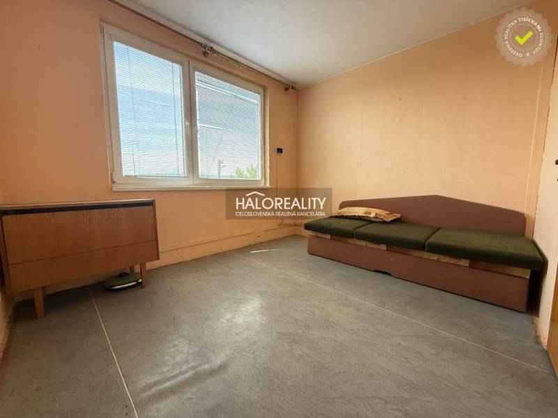 Helles Zimmer mit Sofa in einer 3-Zimmer-Wohnung, Holzmöbel, großes Fenster.