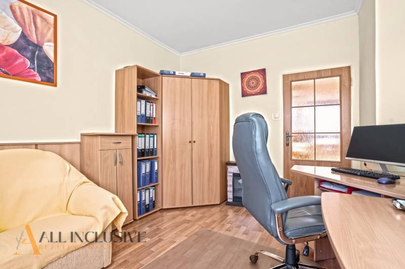 Arbeitszimmer in einem Einfamilienhaus mit Bürostuhl und Boden in Holzoptik.