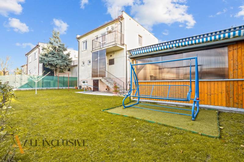 Der Garten des Einfamilienhauses in Dunajská Streda mit einer Schaukel und grünem Rasen.