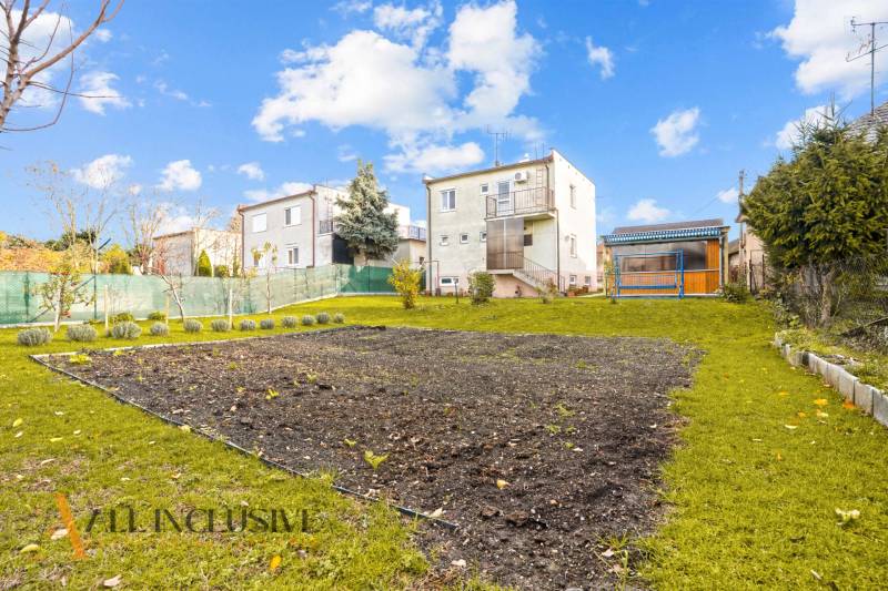 Garten eines Einfamilienhauses in Dunajská Streda mit Rasenfläche und Nutzfläche.