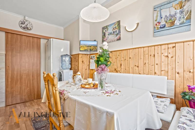 Esszimmer in einem Einfamilienhaus mit Holzelementen, Blumendekoration und servierten Erfrischungen.