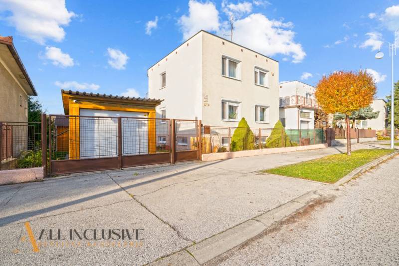 Ein Einfamilienhaus in Dunajská Streda, davor ein gepflegter Vorgarten und ein Metallzaun.