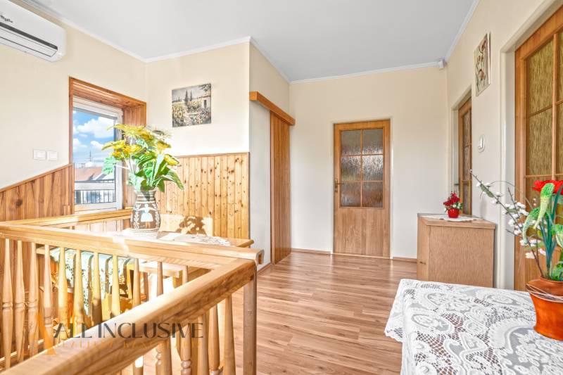 Innenraum eines Einfamilienhauses mit Holzboden, Geländer und Dekorationen.