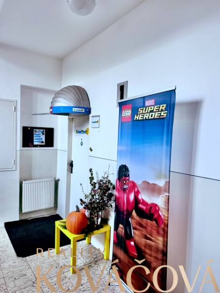 Büros mit Lego Superhelden-Dekoration, Pflanze und Kürbis an der Wand.