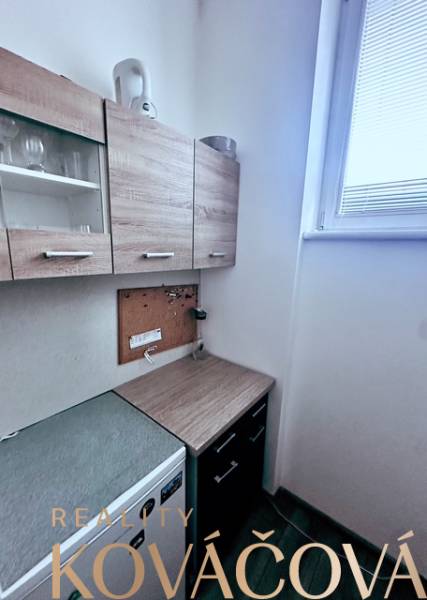 Büros mit Teeküche, Schränke mit Holzdekor und kleines Fenster zur Beleuchtung.