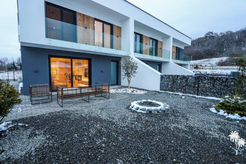 Das Äußere eines Einfamilienhauses in der Modrovka-Straße, Modrovka, mit Steinkreisen und einer Terrasse.