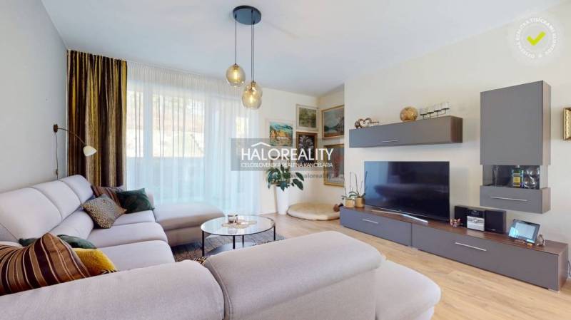 Wohnzimmer in einem Einfamilienhaus mit einem bequemen Sofa und einem Boden in Holzoptik.