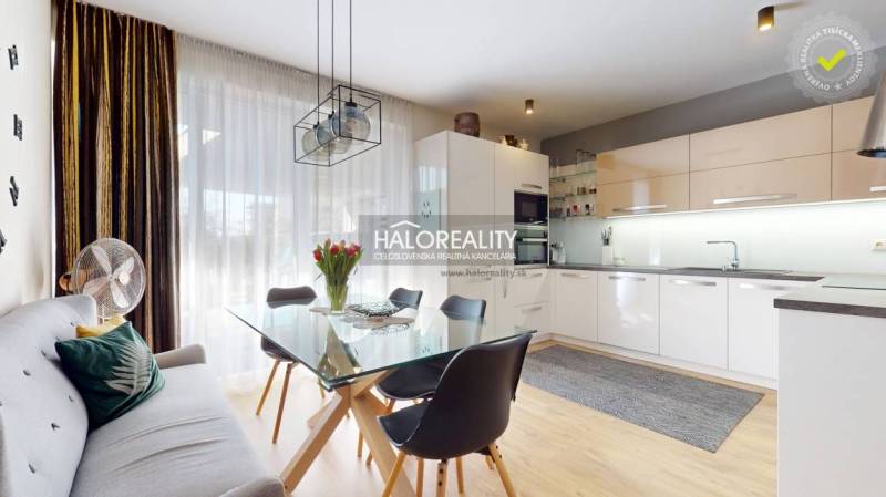 Küche in einem Einfamilienhaus mit Esstisch, Sofa und Holzboden.