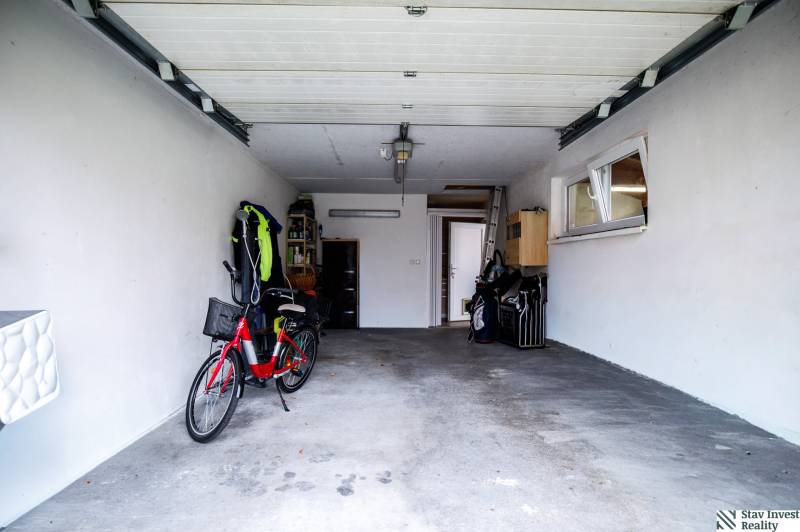Garage in einem Einfamilienhaus mit Fahrrad und offenen Türen, geeignet zur Lagerung.