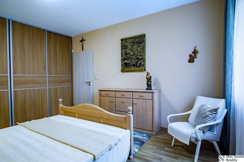 Schlafzimmer in einem Einfamilienhaus mit Holzmöbeln, Bett, Schrank, Sessel, Boden mit Holzdekor.