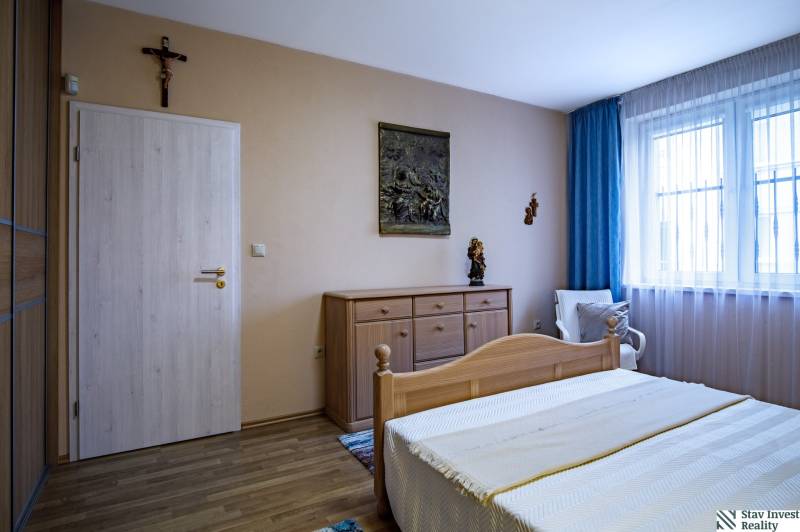 Schlafzimmer mit Holzboden in einem Einfamilienhaus, Holzbett und Kommode.