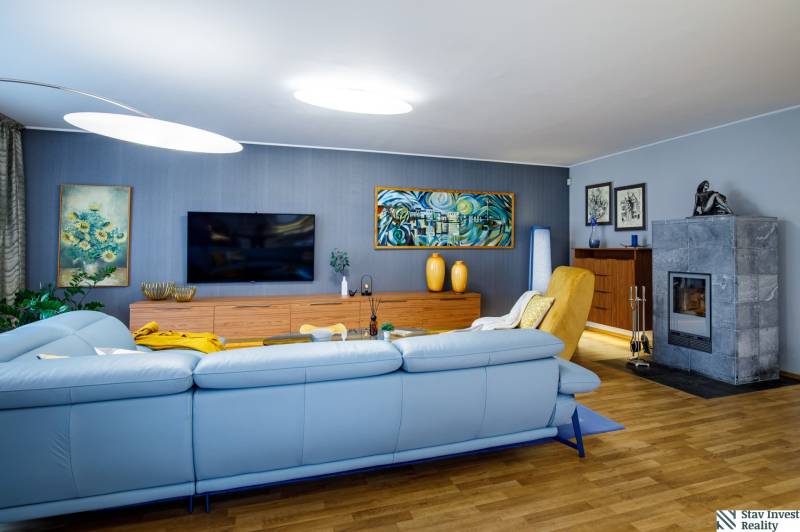 Wohnzimmer in einem Einfamilienhaus mit Kamin, Sofa und Holzboden.