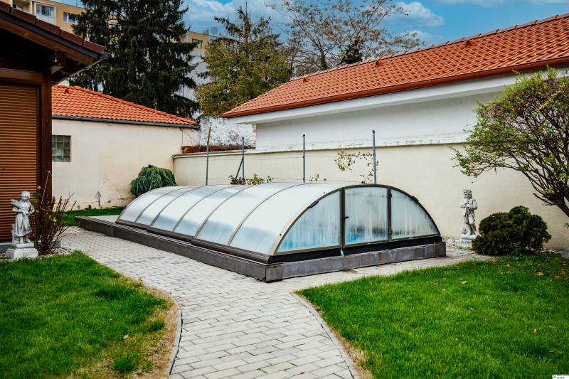 Ein Pool mit Abdeckung im Garten eines Einfamilienhauses in der Školská-Straße in Senec.