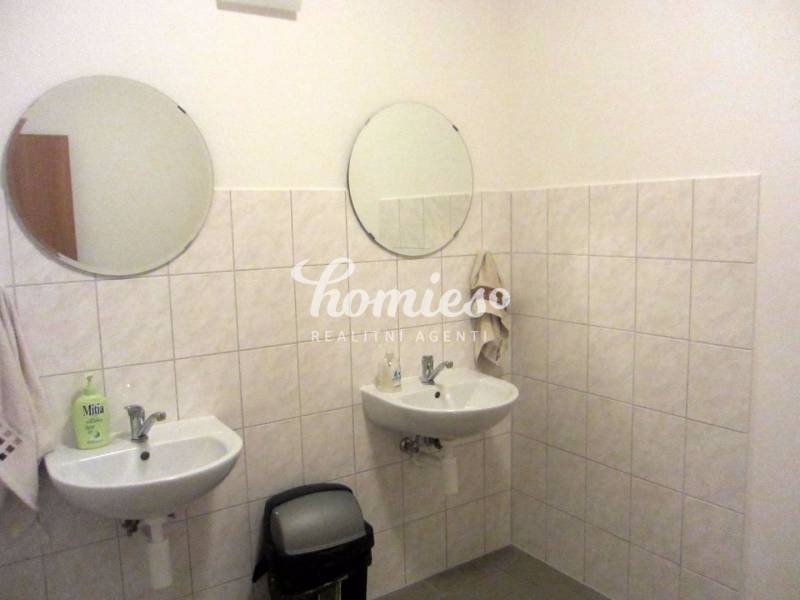 Badezimmer mit zwei Waschbecken und runden Spiegeln im Büro.