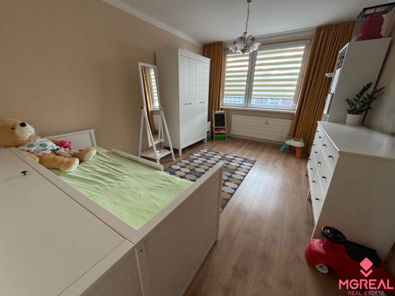 Kinderzimmer mit Holzboden in einer 4-Zimmer-Wohnung, mit weißen Möbeln.