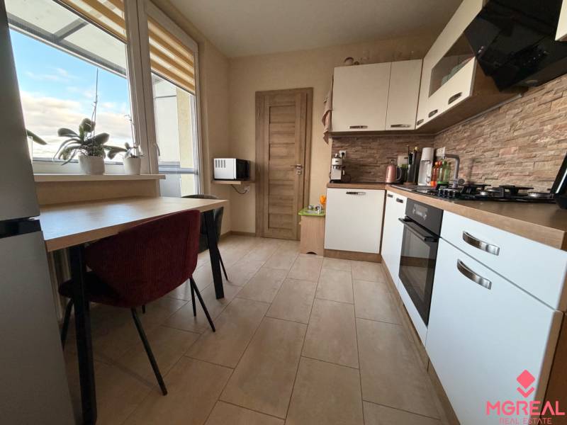 Küche in einer 4-Zimmer-Wohnung mit Fenster, Pflanzen, Küchenzeile und eingebauten Geräten.