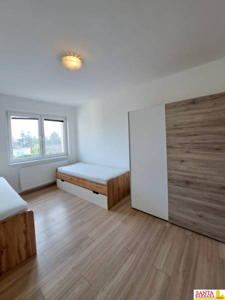 Ein Zimmer in einer 4-Zimmer-Wohnung mit zwei Betten und einem Boden in Holzoptik.