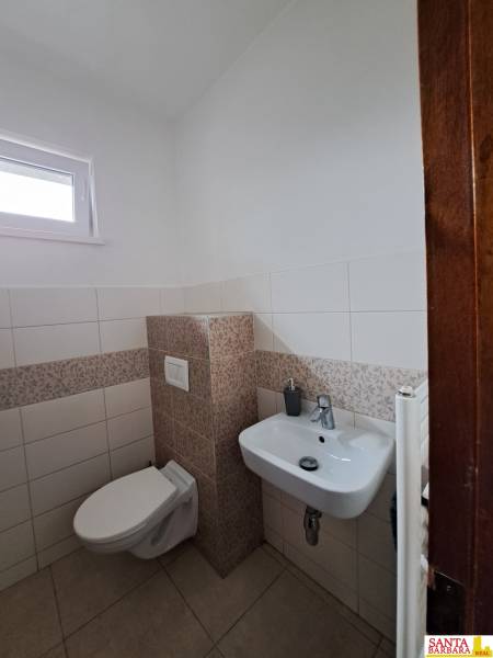 Toilette in einer 4-Zimmer-Wohnung mit weißen und gemusterten Fliesen.