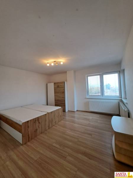 Schlafzimmer in einer 4-Zimmer-Wohnung mit Holzboden, Bett und Schrank.